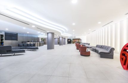 Lobby at the gay-friendly NH Collection Mexico City Reforma hotel. Modern design with gray sofas and columns. Ideal for gay travelers.