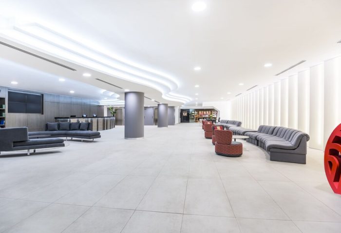 Lobby at the gay-friendly NH Collection Mexico City Reforma hotel. Modern design with gray sofas and columns. Ideal for gay travelers.