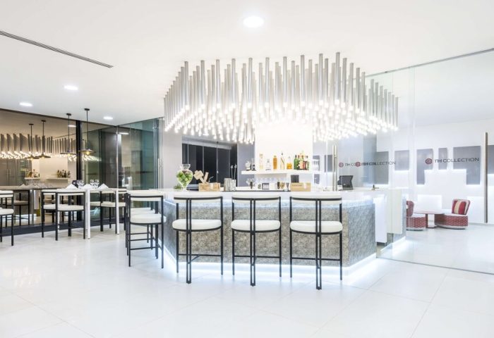 Bar area at the gay-friendly NH Collection Mexico City Reforma hotel. Modern design with stools, tables, and lighting.