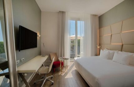 NH Collection Palazzo Cinquecento gay-friendly hotel room. Modern design, bed, desk, and balcony. Perfect for gay travel in Italy.