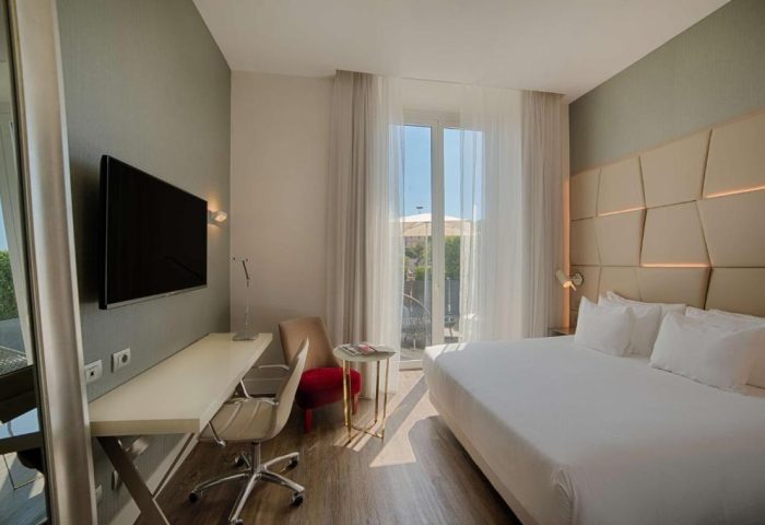 NH Collection Palazzo Cinquecento gay-friendly hotel room. Modern design, bed, desk, and balcony. Perfect for gay travel in Italy.