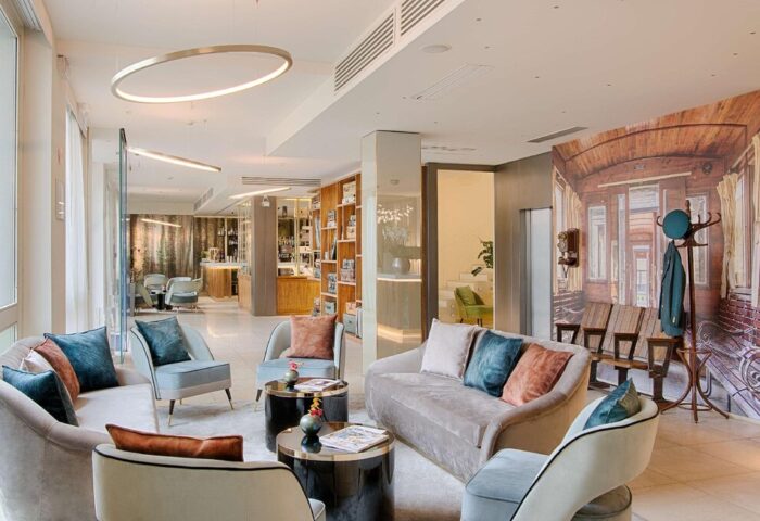 NH Milano Palazzo Moscova's stylish lobby. Gay-friendly hotel with modern seating, bar, and unique train-themed decor. Ideal for gay travelers.
