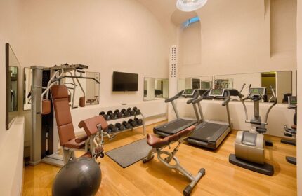 NH Milano Palazzo Moscova gay-friendly hotel gym. Fitness center with weights, treadmills, elliptical machine, and weight machines for a workout.