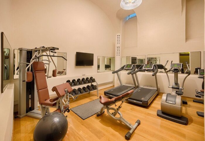 NH Milano Palazzo Moscova gay-friendly hotel gym. Fitness center with weights, treadmills, elliptical machine, and weight machines for a workout.