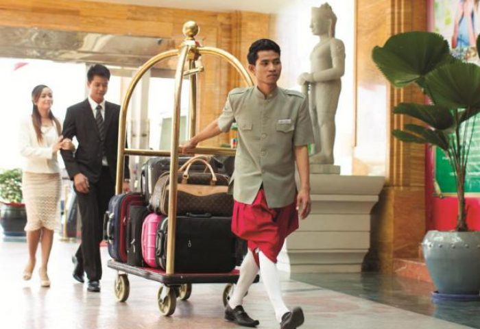 NagaWorld Hotel & Entertainment Complex: Bellhop assists guests with luggage. Gay-friendly hotel with luxury service and amenities.