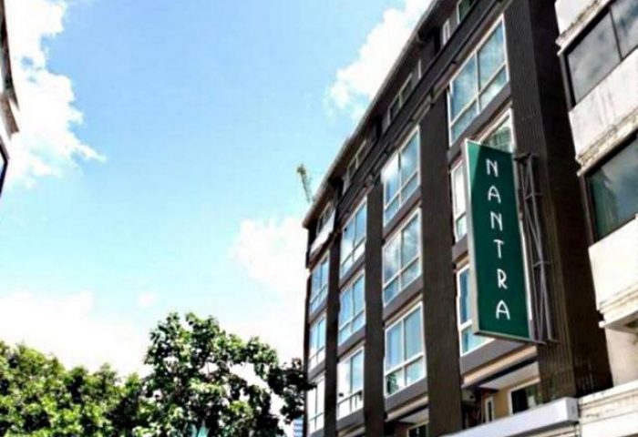 Nantra Silom Hotel exterior. Gay-friendly hotel in Bangkok's Silom district. Modern building with a green sign. Great choice for gay travelers.