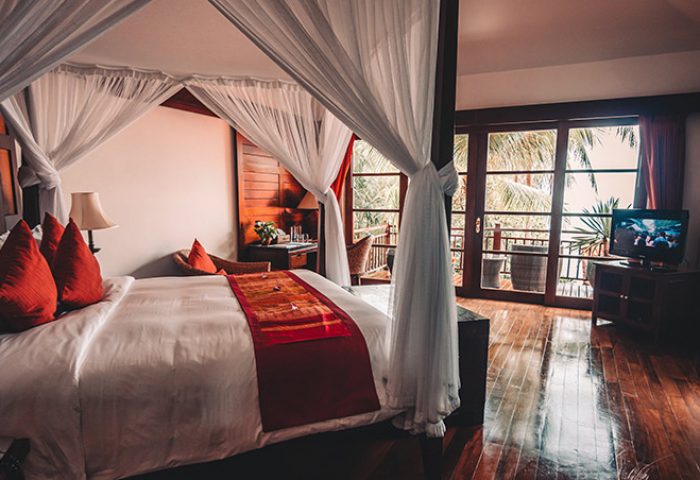 Napasai, A Belmond Hotel, Koh Samui: Gay-friendly hotel room with four-poster bed, balcony, and tropical view. Luxury travel for gay men.
