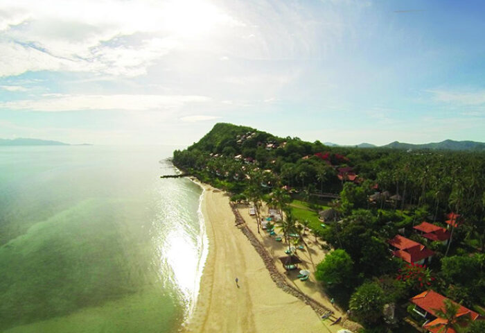 Napasai, A Belmond Hotel, Koh Samui aerial view. Gay-friendly hotel with beach, trees, and villas. Tropical paradise for gay men travel.