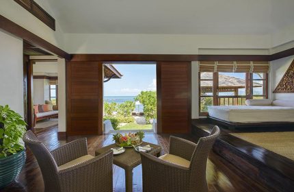 Napasai, A Belmond Hotel, Koh Samui suite. Gay-friendly hotel room with sea view, chairs, table, and bed. Tropical luxury in Thailand.