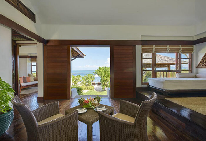 Napasai, A Belmond Hotel, Koh Samui suite. Gay-friendly hotel room with sea view, chairs, table, and bed. Tropical luxury in Thailand.