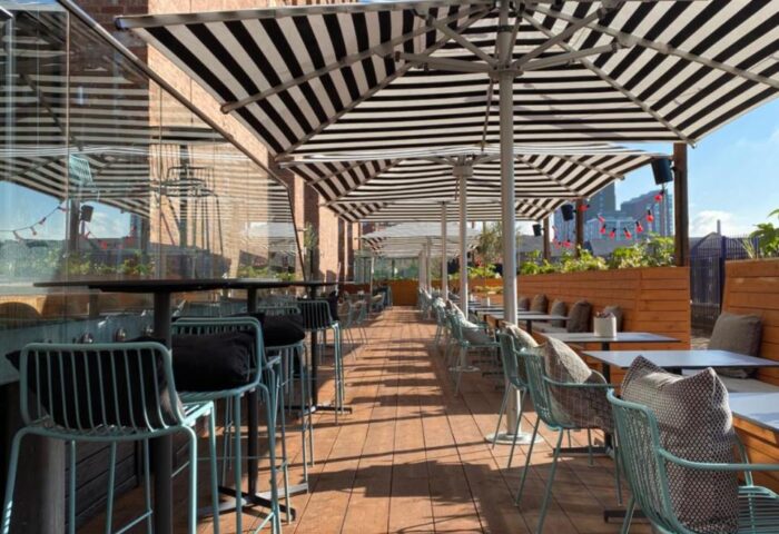 Native Manchester Gay-Friendly Hotel outdoor seating area with striped umbrellas. A stylish spot for gay travelers in Manchester, England.
