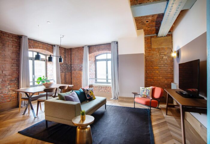 Native Manchester gay-friendly hotel room. Exposed brick, modern furniture, and large windows create a stylish, welcoming space.