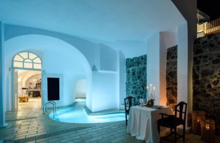 Romantic dining at gay-friendly Nefeles Luxury Suites. Indoor pool, candlelit table for two. Perfect for gay travel in Santorini.