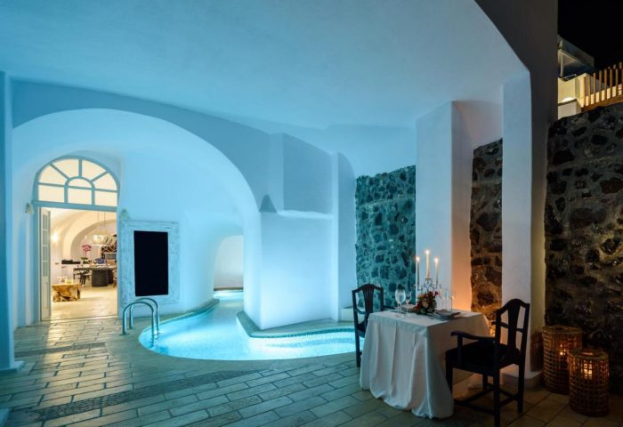 Romantic dining at gay-friendly Nefeles Luxury Suites. Indoor pool, candlelit table for two. Perfect for gay travel in Santorini.