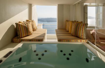 Nefeles Luxury Suites gay-friendly hotel jacuzzi. Santorini suite with sea view. Cushioned seating area by the hot tub.