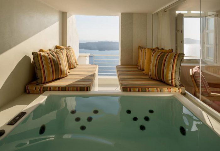 Nefeles Luxury Suites gay-friendly hotel jacuzzi. Santorini suite with sea view. Cushioned seating area by the hot tub.