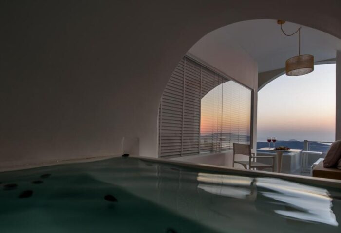 Nefeles Luxury Suites gay-friendly hotel view. Jacuzzi and sunset view from a suite's balcony. Romantic Santorini experience for gay men.