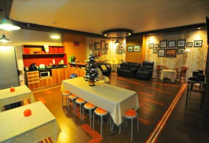 New Batavia Capsule Hotel's common area. A gay-friendly hotel with shared kitchen, tables, and seating for socializing.