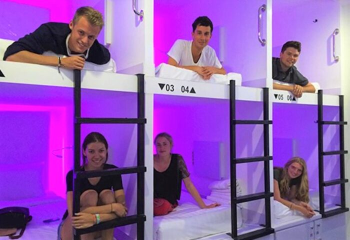 Gay-Friendly New Batavia Capsule Hotel: Guests relaxing in their capsule beds. A modern, social, and affordable lodging option for gay travelers.