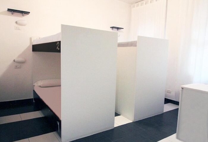 New Generation Hostel Milan Center gay-friendly hotel room. Bunk beds with privacy panels, modern design, and clean aesthetic.