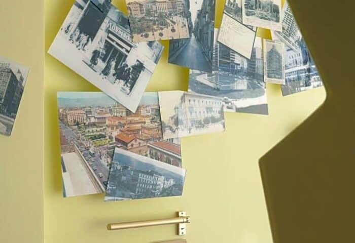 Wall decor in a new gay-friendly hotel room. Features vintage city photos, mirror, and clothes rack. Ideal for gay men travel advice.