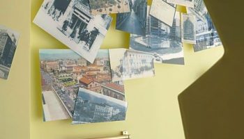 Wall decor in a new gay-friendly hotel room. Features vintage city photos, mirror, and clothes rack. Ideal for gay men travel advice.