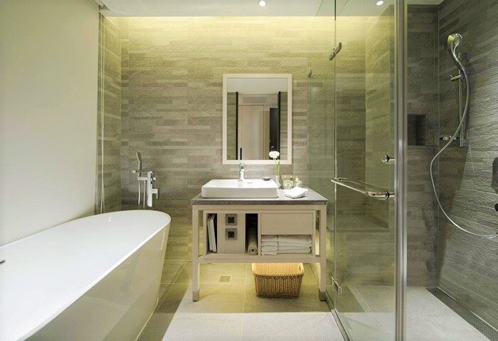New Riverview Suites gay-friendly hotel bathroom. Modern design with tub, shower, sink, and mirror. Perfect for gay travelers' comfort.