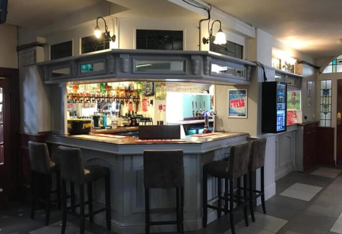 New Union Guesthouse's bar area. Gay-friendly hotel with bar stools, drinks, and a vintage design. A welcoming space for gay travelers.