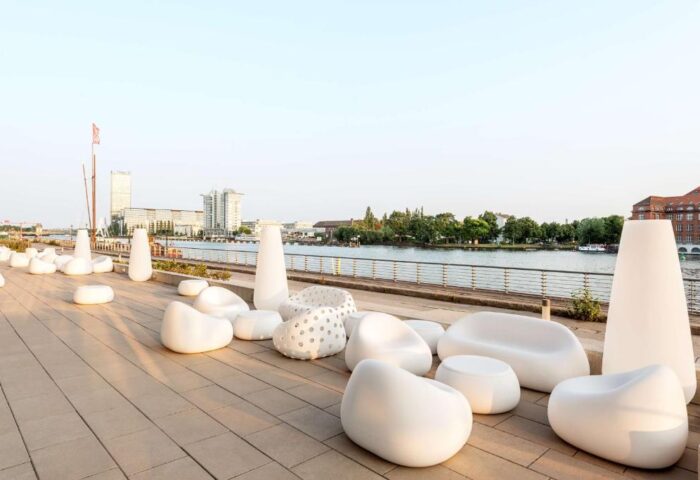 Nhow Berlin Hotel's outdoor lounge area by the river. Modern white furniture for gay travelers. Gay-Friendly Hotel Nhow Berlin Hotel.