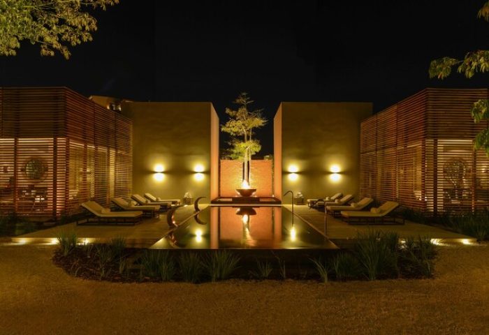 Night view of Nizuc Resort and Spa, a gay-friendly hotel. Pool reflects lights, creating a serene, luxurious ambiance for gay travelers.