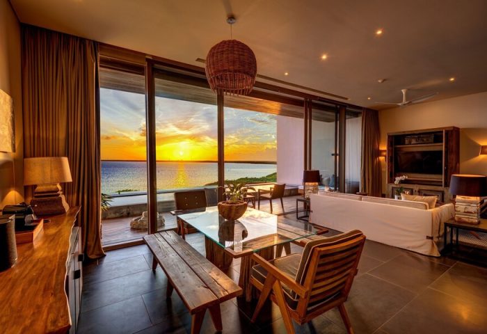Nizuc Resort & Spa gay-friendly hotel suite. Dining area with sunset ocean view. Upscale travel for gay men.