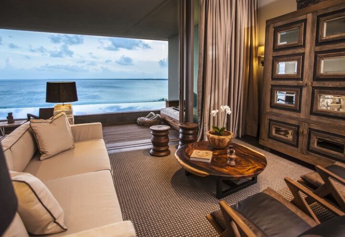 Nizuc Resort and Spa gay-friendly hotel room. Ocean view suite with sofa, wood furniture, and balcony. Luxury travel for gay men.