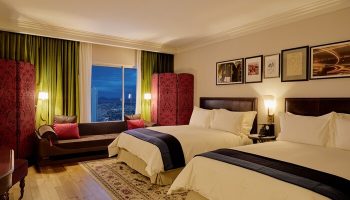 NoMad Las Vegas hotel room. Gay-friendly hotel with two beds, sofa, and city view. Luxurious decor for gay travelers. #NoMadLasVegas