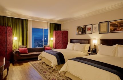 NoMad Las Vegas hotel room. Gay-friendly hotel with two beds, sofa, and city view. Luxurious decor for gay travelers. #NoMadLasVegas