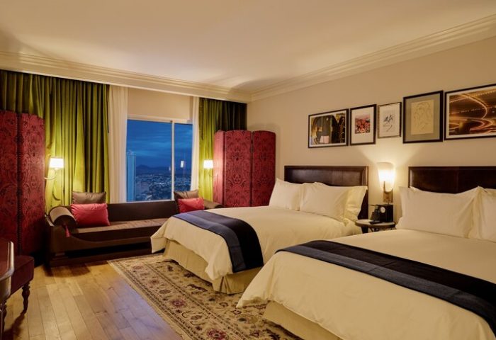 NoMad Las Vegas hotel room. Gay-friendly hotel with two beds, sofa, and city view. Luxurious decor for gay travelers. #NoMadLasVegas