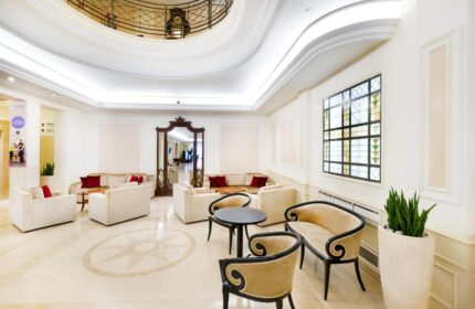 Novotel Budapest Centrum Hotel lobby. Gay-friendly hotel with seating areas, ornate mirror, and decorative window. Elegant design.