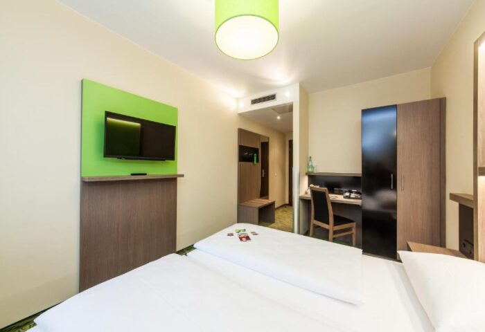 Novum Hotel Aldea Berlin Zentrum room. Gay-friendly hotel with double bed, TV, desk, and closet. Modern design in central Berlin.