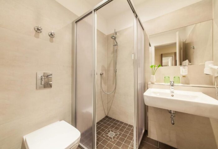 Novum Hotel Aldea Berlin Zentrum bathroom. Shower cabin, sink, and toilet in a modern, gay-friendly hotel. Perfect for gay men travelers.