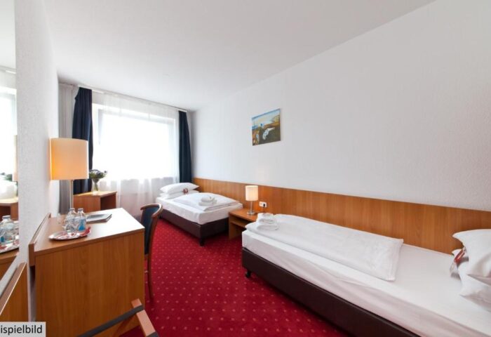 Novum Hotel Aldea Berlin Zentrum: Gay-friendly hotel room with twin beds, desk, and red carpet. A comfortable stay in Berlin for gay travelers.