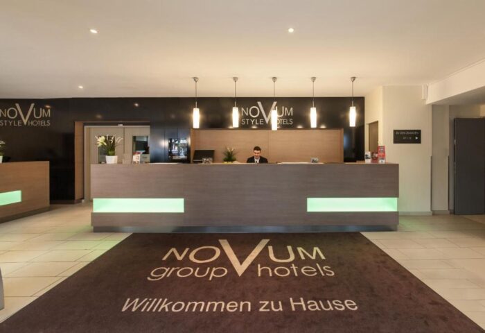 Reception area at Novum Hotel Aldea Berlin Zentrum, a gay-friendly hotel. Modern design, warm lighting, and welcoming atmosphere.