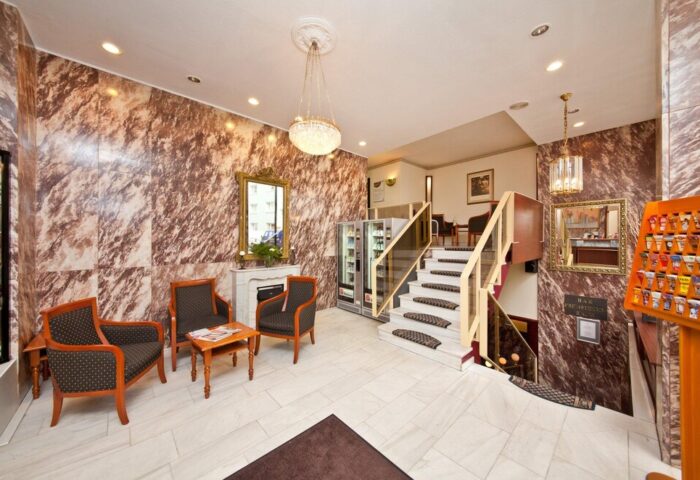 Novum Hotel Leonet Köln Altstadt lobby. Gay-friendly hotel interior with seating, stairs, & marble walls in Cologne. Gay travel advice.