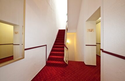 Novum Hotel Leonet Köln Altstadt staircase. Red carpeted stairs in this gay-friendly hotel. Perfect for gay travel in Cologne, Germany.