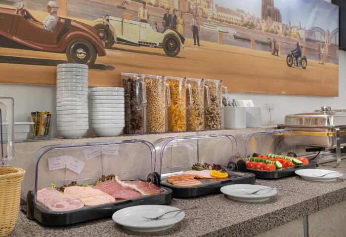 Breakfast buffet at Novum Hotel Leonet Köln Altstadt, a gay-friendly hotel. Cold cuts, cereals, and warm dishes are available for guests.