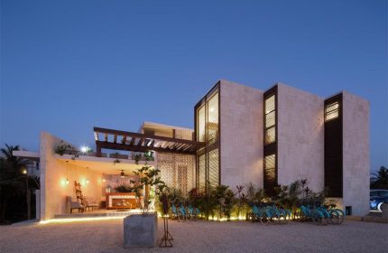 O' Tulum Boutique Hotel, an adults-only gay-friendly hotel. Exterior view at dusk, showing the modern architecture and bikes available for guests.