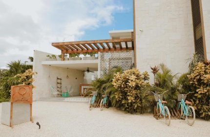 O' Tulum Boutique Hotel adults-only exterior. Gay-friendly hotel with bikes, plants, and modern design. Tulum, Mexico travel destination.