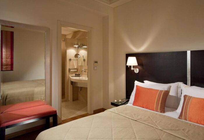 O&B Athens Boutique Hotel room. Gay-friendly hotel with bed, pillows, bathroom, and seating area. Modern interior design for gay men travelers.
