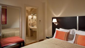 O&B Athens Boutique Hotel room. Gay-friendly hotel with bed, pillows, bathroom, and seating area. Modern interior design for gay men travelers.