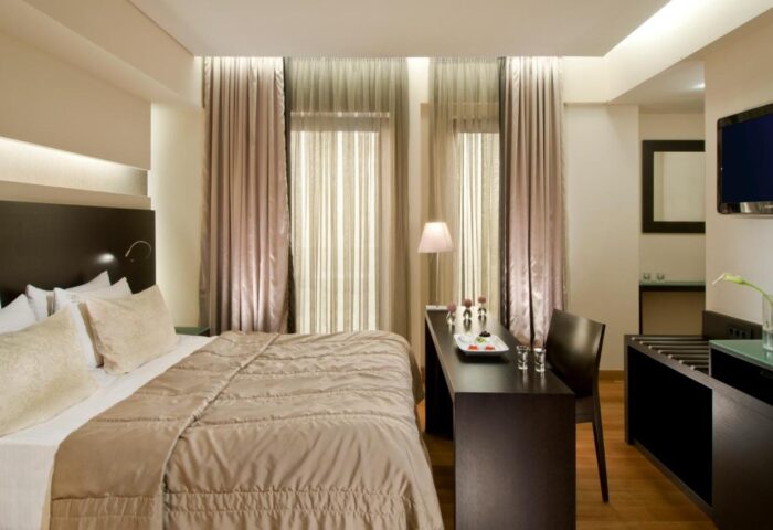 O&B Athens Boutique Hotel gay-friendly room. Modern design, double bed, desk with snacks, and TV. Ideal for gay travelers in Athens.