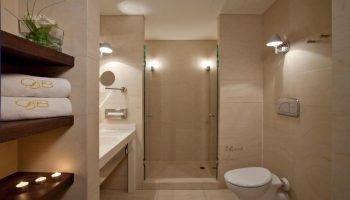 O&B Athens Boutique Hotel bathroom. Gay-friendly hotel with shower, sink, and toilet. Towels with the O&B logo. Modern design.