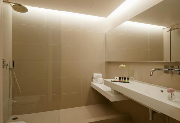 Bathroom at O&B Athens Boutique Hotel, a gay-friendly hotel. Features shower, sink, mirror, toiletries. Modern design for gay travelers.